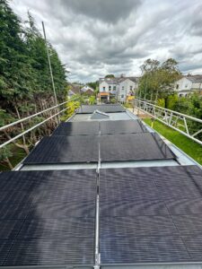 All black Jinko solar panels installed on a flat roof.